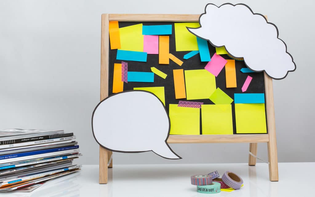 Tafel mit Sprechblasen und Post-its.