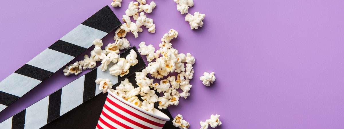 Popcorn im Becher auf einem lila Hintergrund