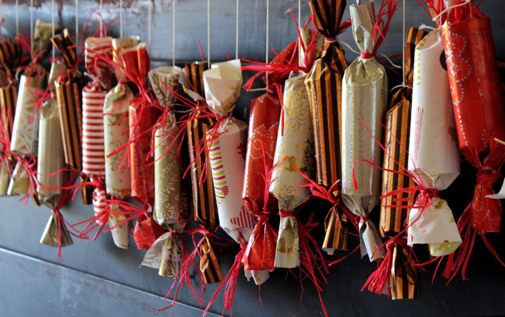 Adventskalender eingepackt in rotem und goldenem Geschenkpapier