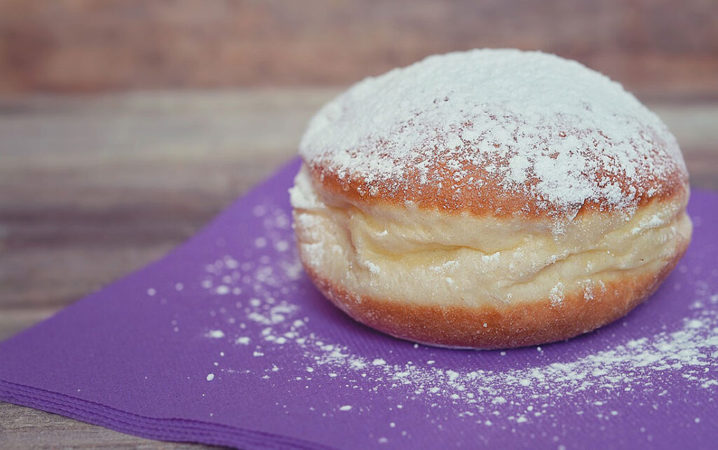 Berliner mit Puderzucker auf lila Serviette